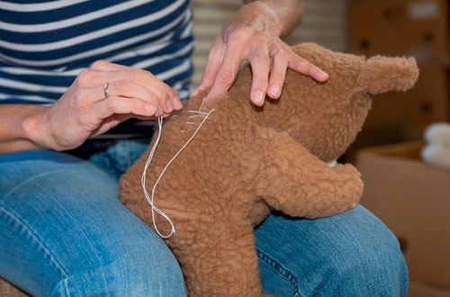 Echte Handarbeit - dem Bär wird der Rücken zugenäht